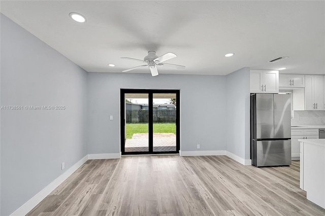 interior space with a ceiling fan, baseboards, visible vents, and light wood-style floors