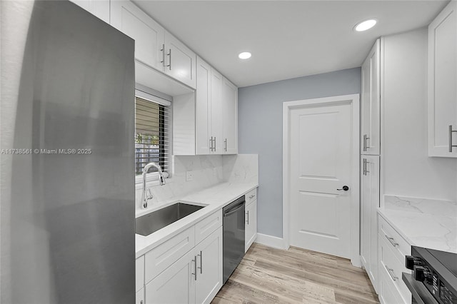 kitchen with a sink, white cabinets, light wood finished floors, stainless steel appliances, and recessed lighting