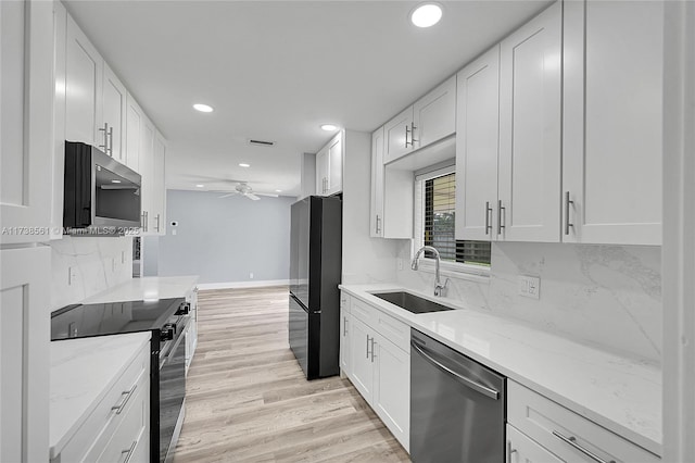 kitchen featuring sink, white cabinetry, light stone counters, appliances with stainless steel finishes, and ceiling fan