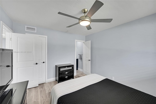 bedroom with baseboards, a ceiling fan, light wood finished floors, and visible vents