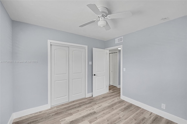 unfurnished bedroom with ceiling fan, light wood-style flooring, baseboards, visible vents, and a closet