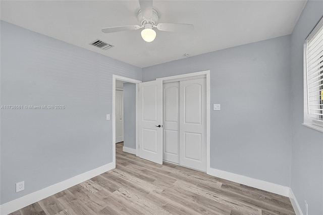 unfurnished bedroom featuring baseboards, light wood-style floors, and a closet
