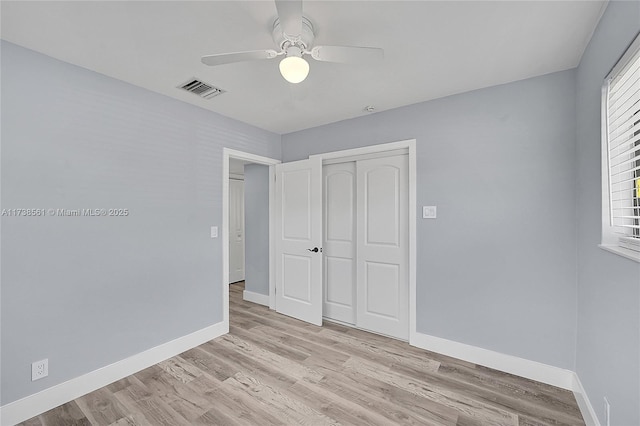 unfurnished bedroom featuring ceiling fan, a closet, and light wood-type flooring