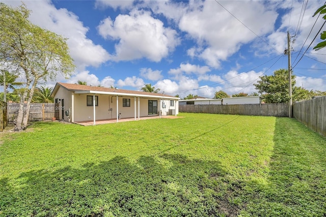 rear view of house with a patio, a fenced backyard, a lawn, and stucco siding