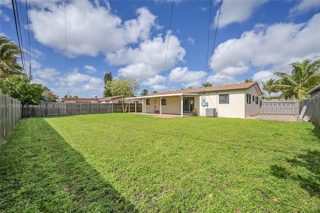 rear view of house with a lawn, cooling unit, a fenced backyard, a patio, and stucco siding
