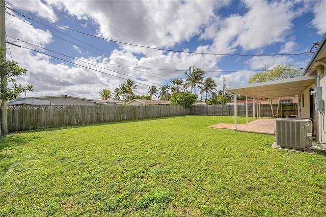 view of yard with a fenced backyard, central AC unit, and a patio area
