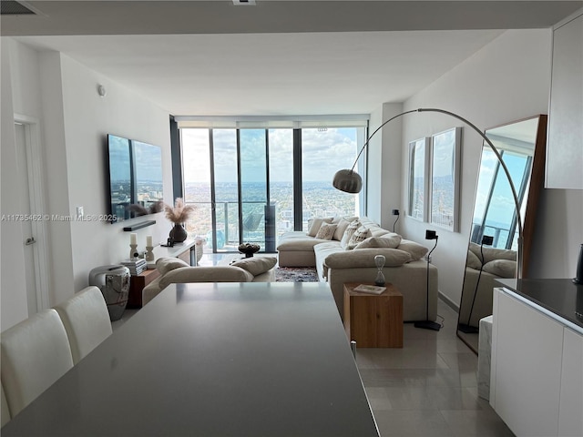 living room with expansive windows and light tile patterned flooring