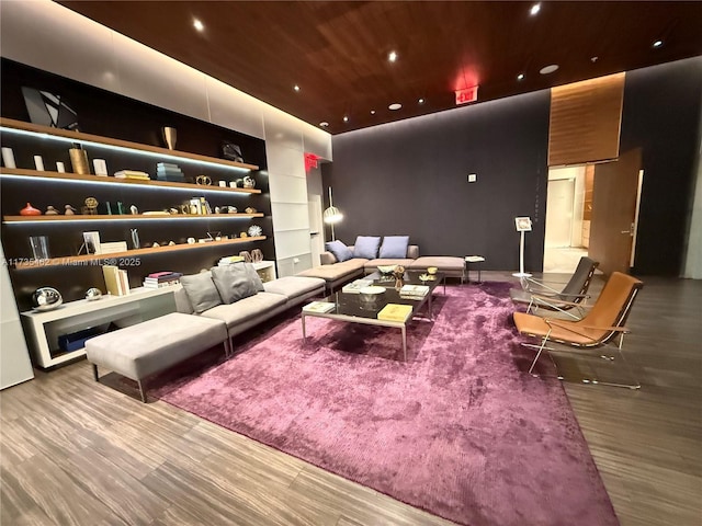 home theater room featuring hardwood / wood-style flooring, built in features, and wooden ceiling