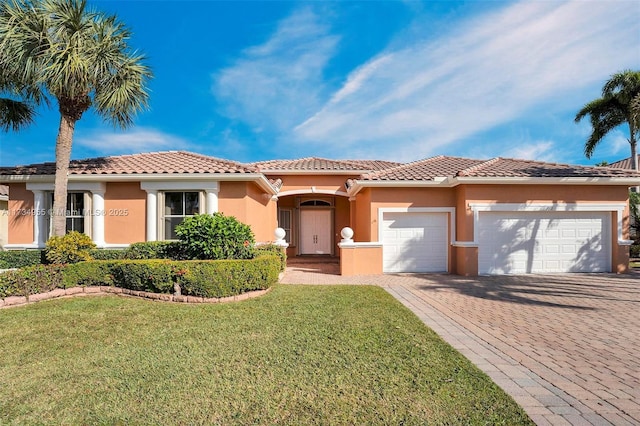 mediterranean / spanish home with a garage and a front lawn