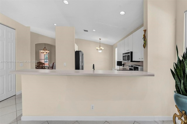 kitchen with an inviting chandelier, stainless steel appliances, decorative light fixtures, and kitchen peninsula