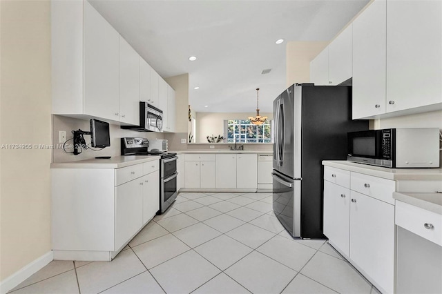 kitchen featuring pendant lighting, white cabinetry, stainless steel appliances, a notable chandelier, and light tile patterned flooring