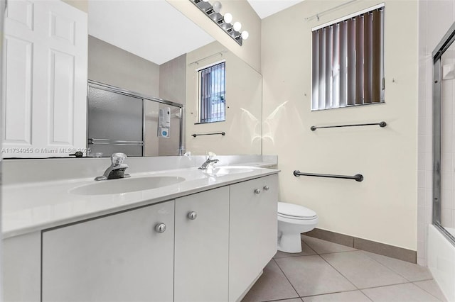 full bathroom with bath / shower combo with glass door, tile patterned floors, toilet, and vanity