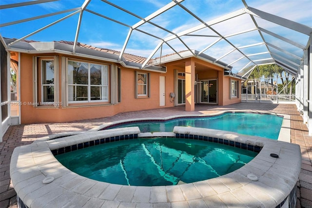 view of swimming pool with a lanai, a patio area, and an in ground hot tub