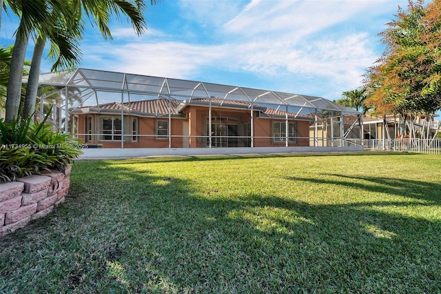 rear view of house featuring a lanai and a lawn