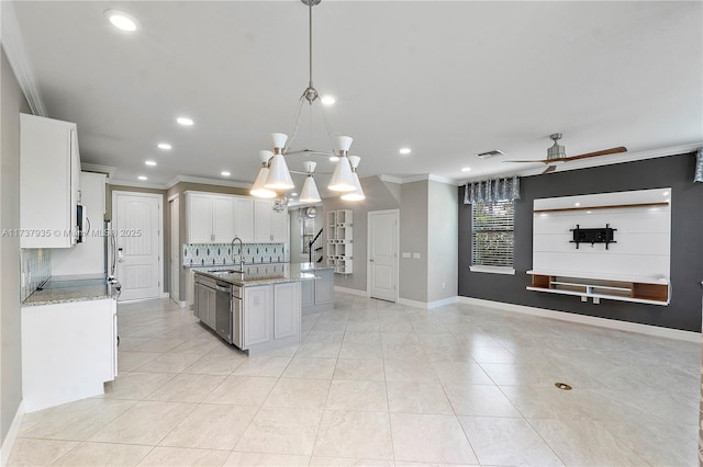 kitchen featuring sink, decorative light fixtures, a center island with sink, ornamental molding, and white cabinets