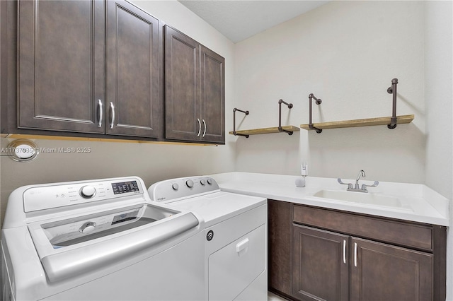 laundry room featuring cabinets, sink, and independent washer and dryer