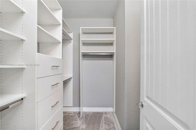 bathroom with tile patterned flooring, vanity, and walk in shower