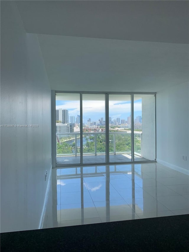 spare room featuring tile patterned flooring and expansive windows