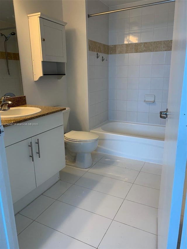 full bathroom featuring vanity, tiled shower / bath combo, tile patterned floors, and toilet