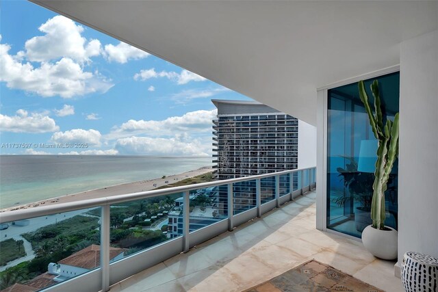 balcony featuring a water view and a view of the beach