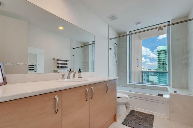 full bathroom featuring vanity, bath / shower combo with glass door, tile patterned floors, and toilet