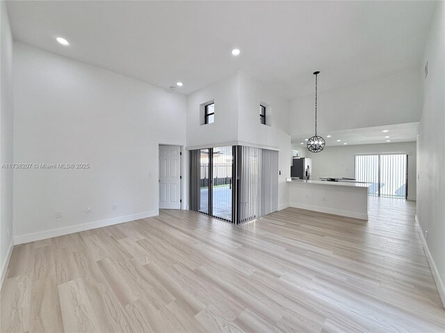 entryway with a towering ceiling and light hardwood / wood-style flooring