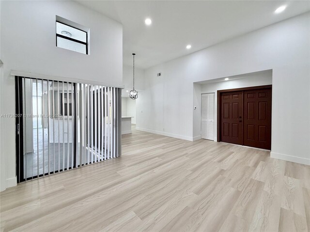 entrance foyer with a towering ceiling and light hardwood / wood-style flooring