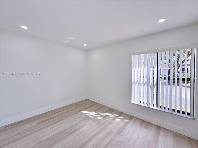 empty room featuring a wealth of natural light and light hardwood / wood-style floors