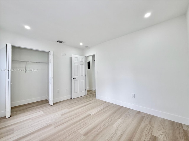 unfurnished bedroom featuring light hardwood / wood-style floors and a closet