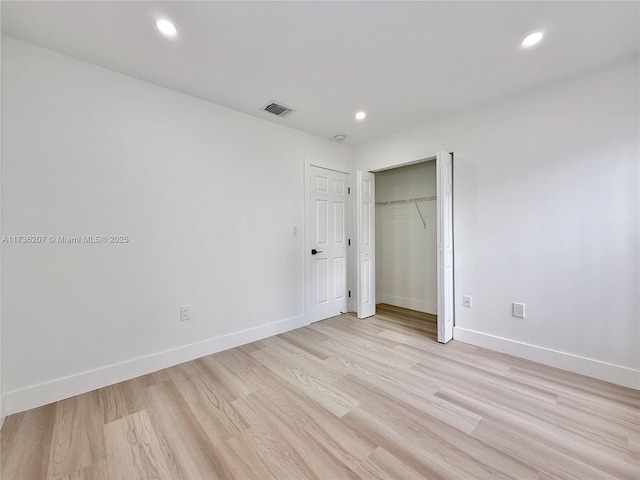 unfurnished bedroom featuring light hardwood / wood-style floors and a closet