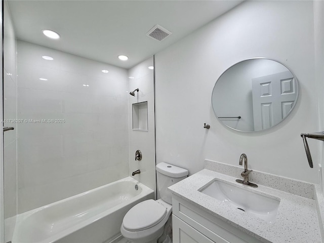 full bathroom with tiled shower / bath, vanity, and toilet