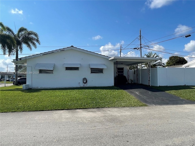 view of side of property featuring a carport and a yard