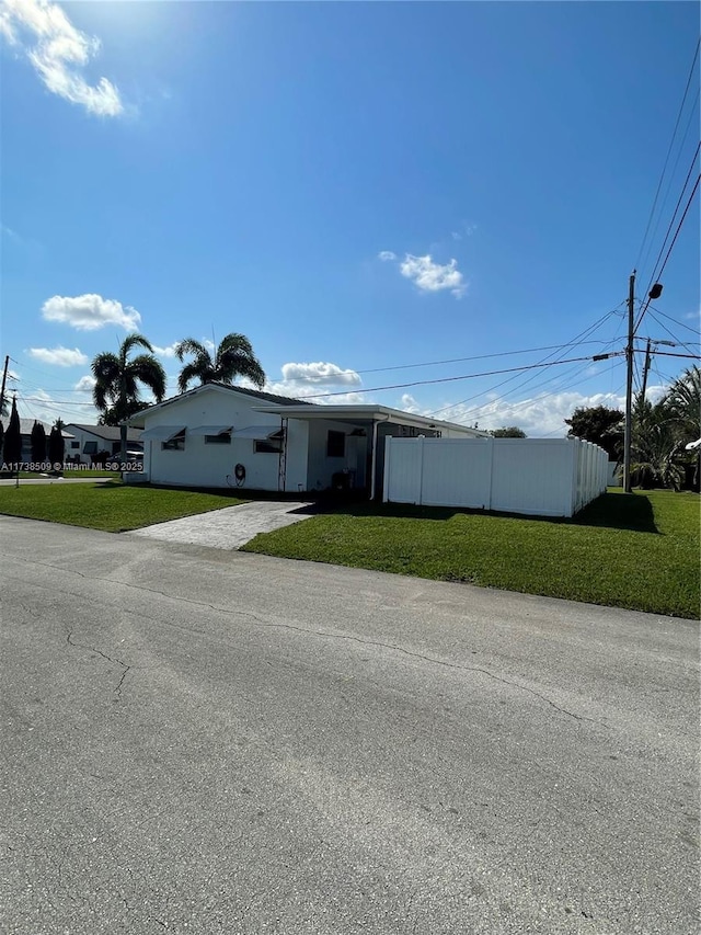 view of front of home with a front yard and a carport