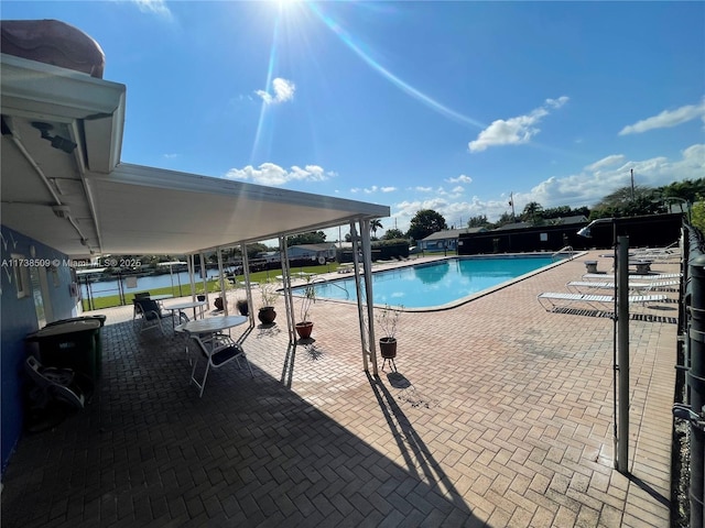 view of swimming pool with a patio and a water view