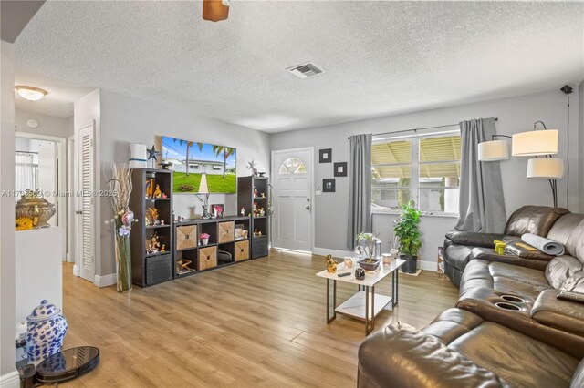 2701 NW 52nd Ct, Tamarac, FL 33309 - living room featuring light wood-style floors, baseboards, and a textured ceiling
