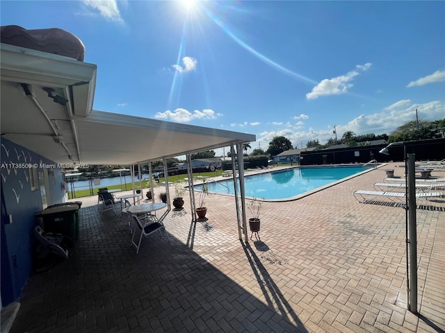 view of pool featuring a patio and a water view