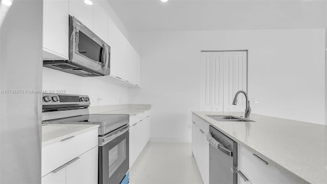 kitchen featuring light tile patterned flooring, sink, white cabinets, light stone counters, and stainless steel appliances