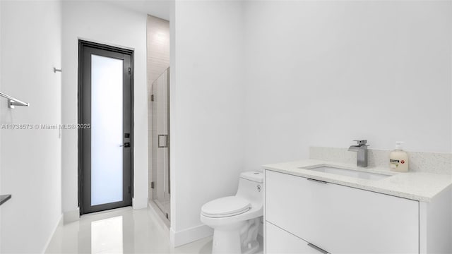 bathroom with vanity, toilet, and a shower with door