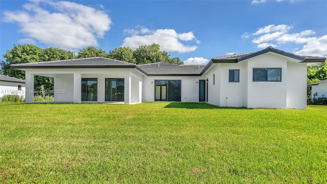 rear view of house featuring a yard