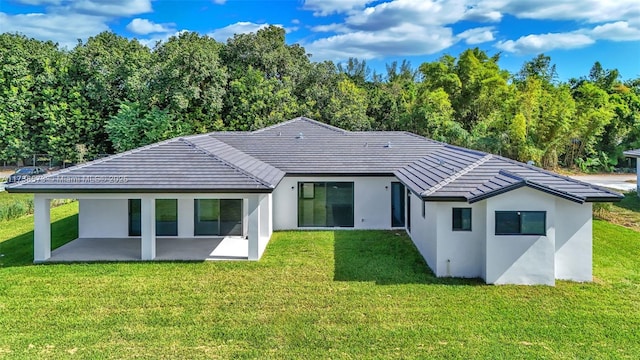 back of property featuring a patio and a lawn