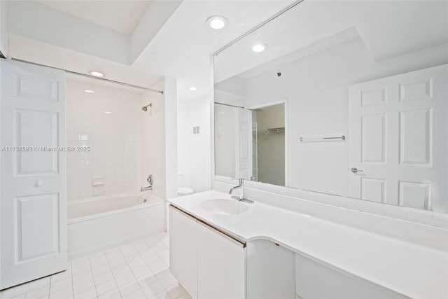 bathroom with tile patterned flooring, tiled shower / bath, and vanity