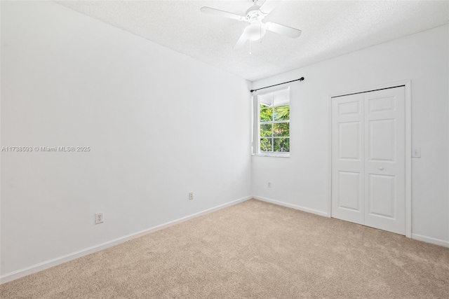 carpeted spare room with ceiling fan and a textured ceiling