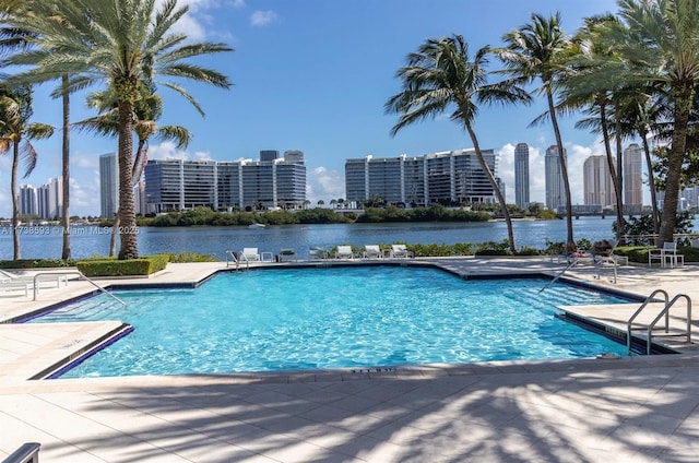 view of pool with a patio and a water view