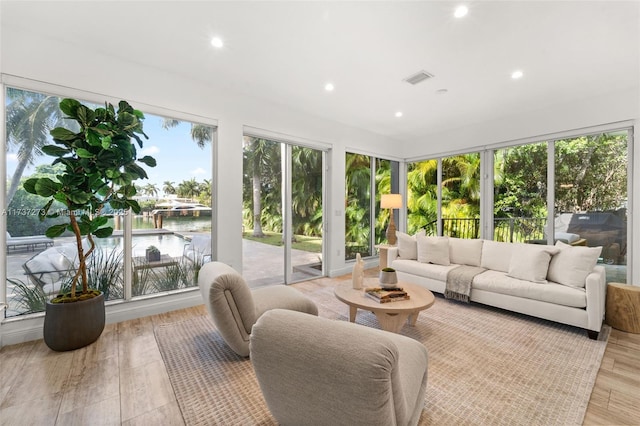 sunroom featuring a water view