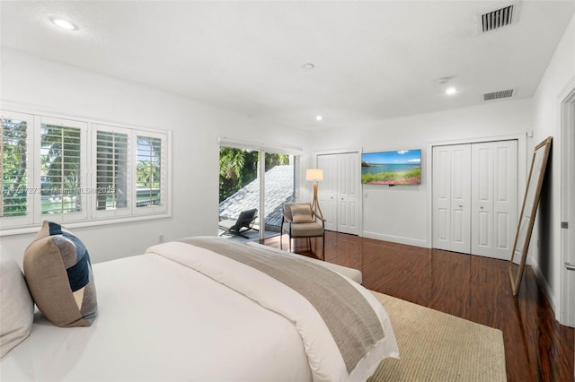 bedroom with multiple closets, dark hardwood / wood-style flooring, and access to outside