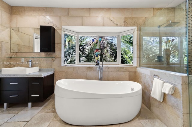 bathroom featuring vanity, independent shower and bath, and tile walls