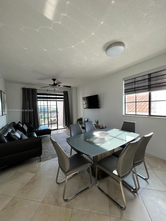 dining area with light tile patterned floors, a textured ceiling, and ceiling fan