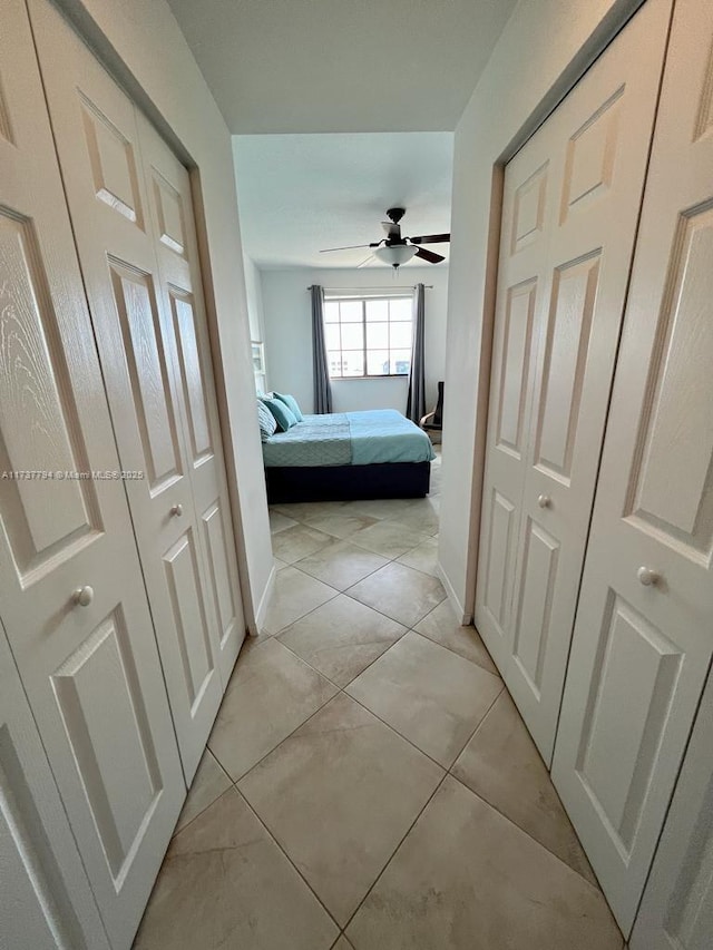 unfurnished bedroom featuring ceiling fan, a closet, and light tile patterned floors