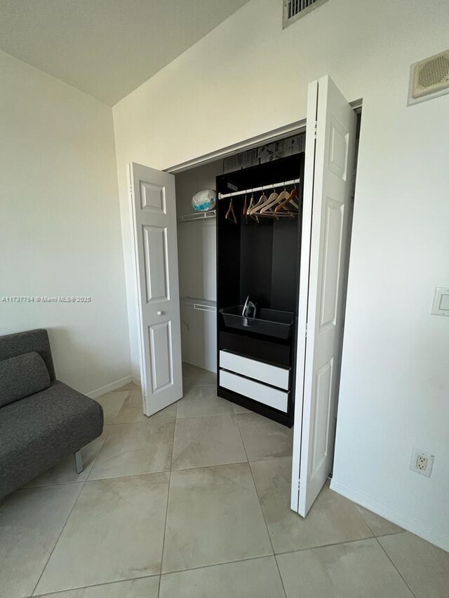 tiled bedroom with a closet