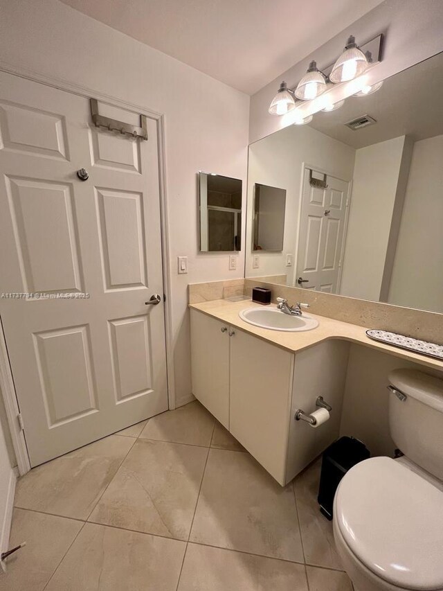 bathroom with tile patterned flooring, vanity, and toilet